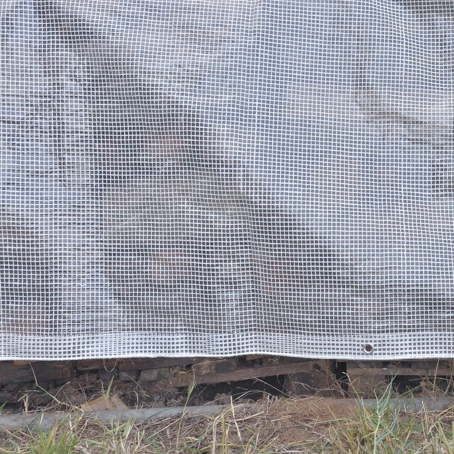 Dettaglio di un telo di copertura bianco con motivo quadrato.