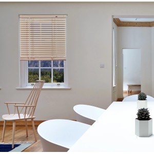 Veneziana in legno chiaro su una finestra in un soggiorno.