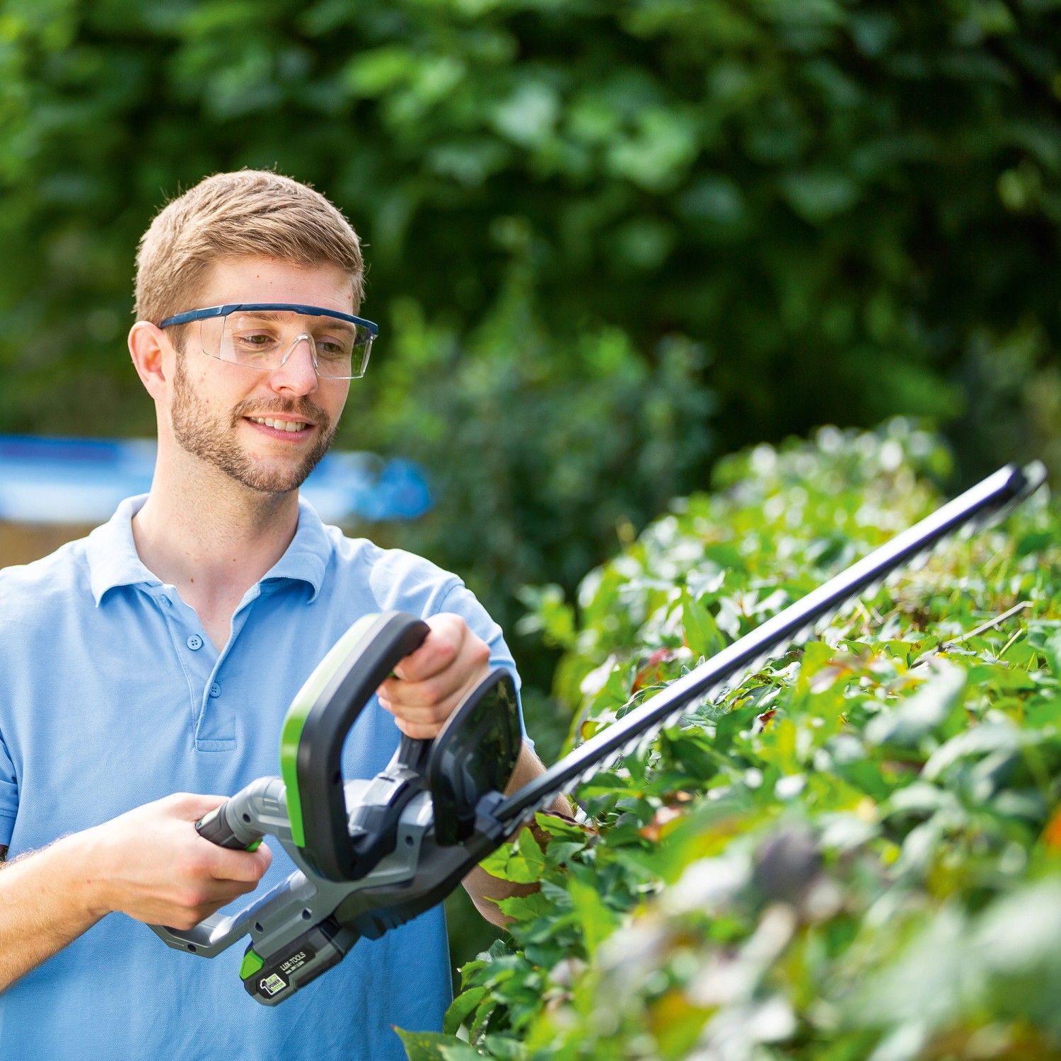 Uomo taglia siepe con tagliasiepi a batteria LUX A-HS-20/52 del 1 PowerSystem.
