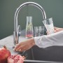 Grohe Blue Pure BauCurve Starter Kit: Miscelatore monocomando che riempie un bicchiere d'acqua.