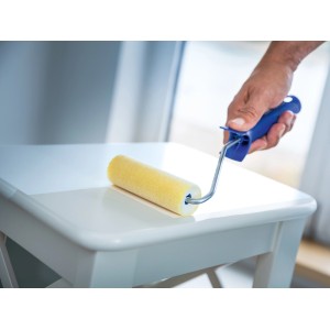 Rullo floccato LUX (2 pz.) mentre dipinge un tavolo. Rullo per pittura per superfici lisce.