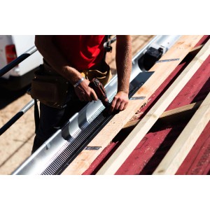 Installazione di una copertura in lamiera t.b.t. su un tetto.