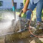 Gardena Comfort Cleaning Sprayer ecoPulse™ in uso per pulire una pala.