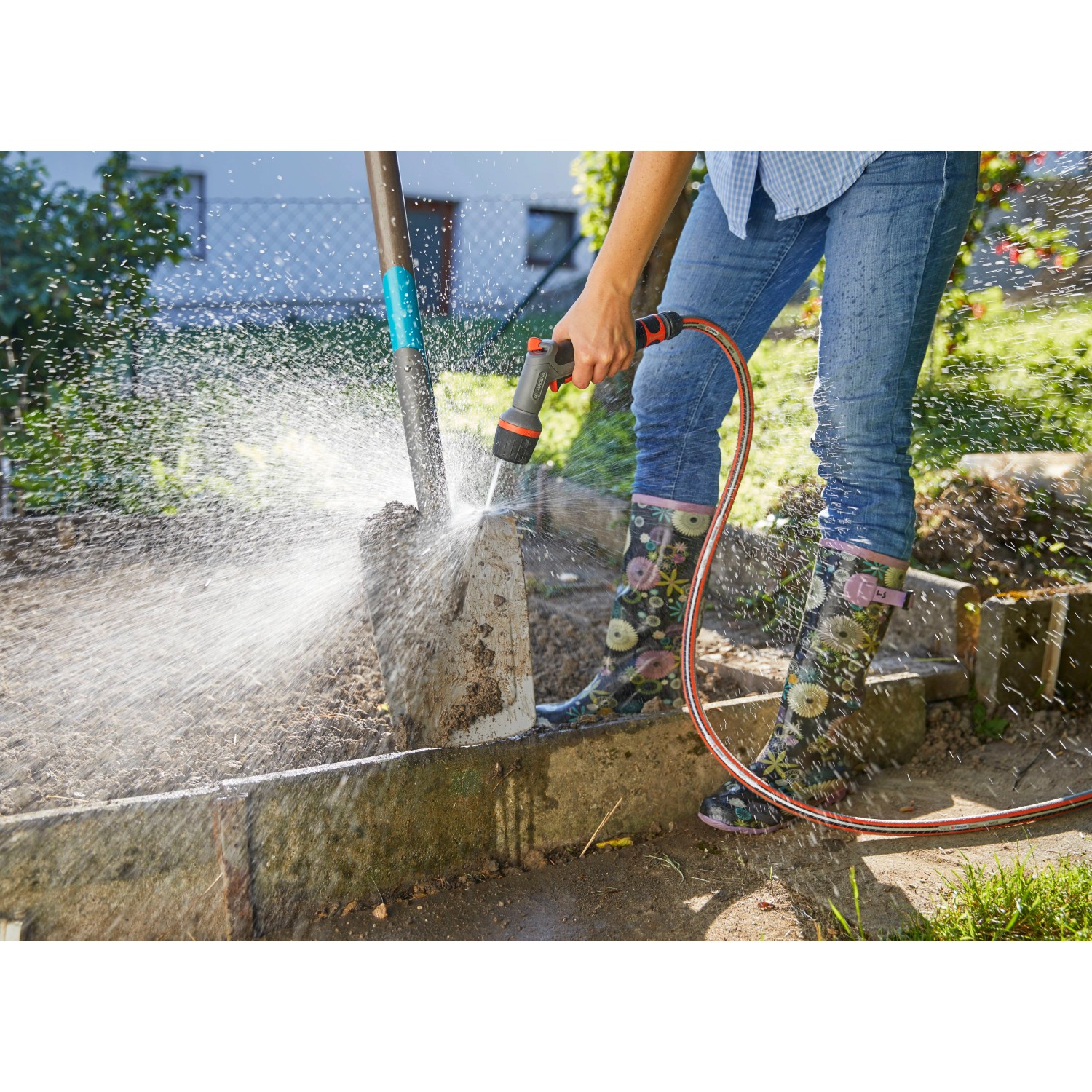 Gardena Comfort Cleaning Sprayer ecoPulse™ in uso per pulire una pala.