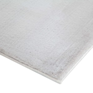 Dettaglio di un tappeto a pelo lungo monocolore chiaro.