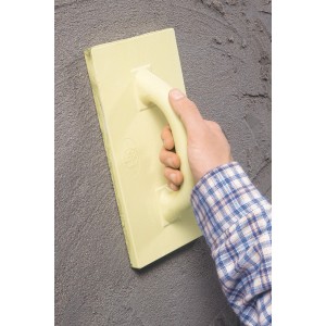 Frattazzo in plastica LUX (140x280mm) in uso per lisciare l'intonaco.
