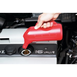 Brocca graduata rossa LUX (1000 ml) che versa olio in un motore.