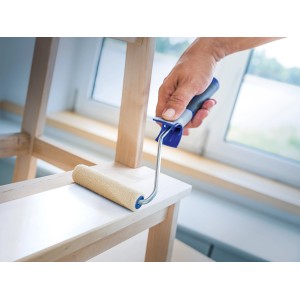 Mano che dipinge il legno con LUX Filtroller 12 cm. Rullo per pittura per superfici lisce.
