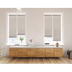 Due tende a rullo grigie t.b.t. in un soggiorno luminoso.