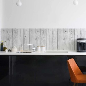 Pannello paraschizzi cucina con decoro legno t.b.t. come rivestimento sopra una cucina nera.