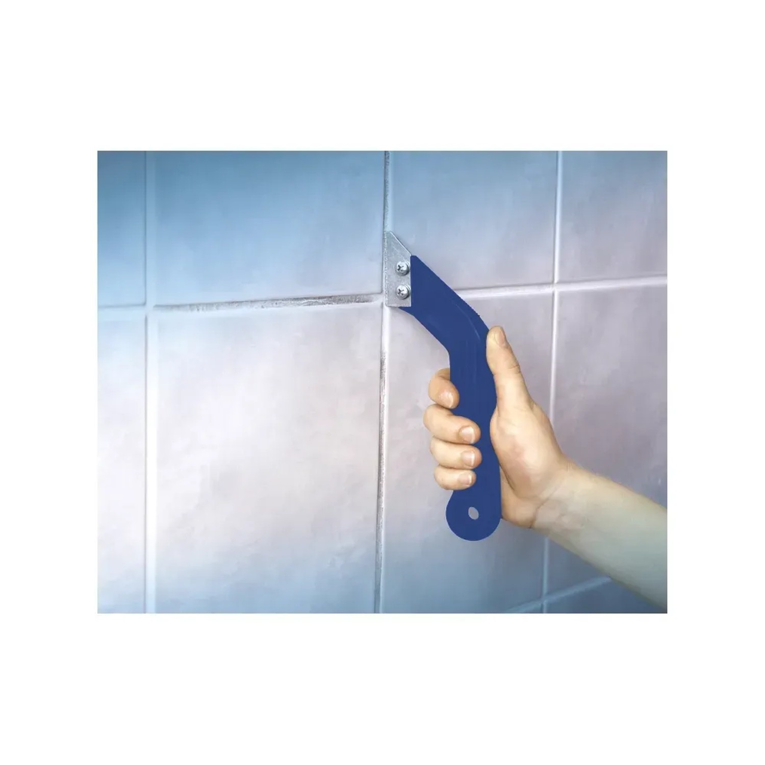 Mano che tiene il pulitore per fughe LUX in metallo duro Classic sulle piastrelle. Strumento per pulire le fughe delle piastrelle.