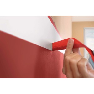 Nastro adesivo rosso per pittori applicato su una parete.