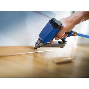 Chiodatrice pneumatica LUX Comfort in uso per fissare una striscia di legno.