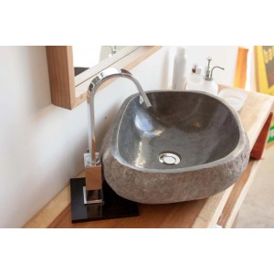 Lavabo in pietra naturale (Lavandini) con rubinetto su ripiano in legno.