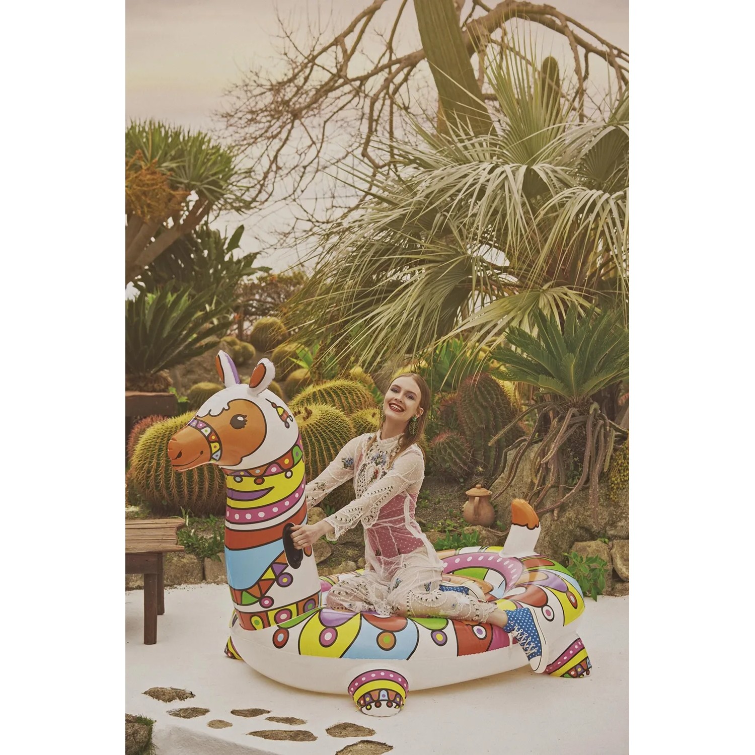 Donna su colorato gonfiabile Bestway POP Llama (193 cm) in giardino.