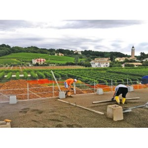 Operai che spargono t.b.t. Sabbie davanti a un paesaggio pittoresco.