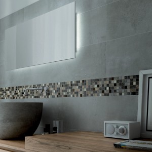 Bagno con piastrelle grigie e bordo di piastrelle a mosaico.
