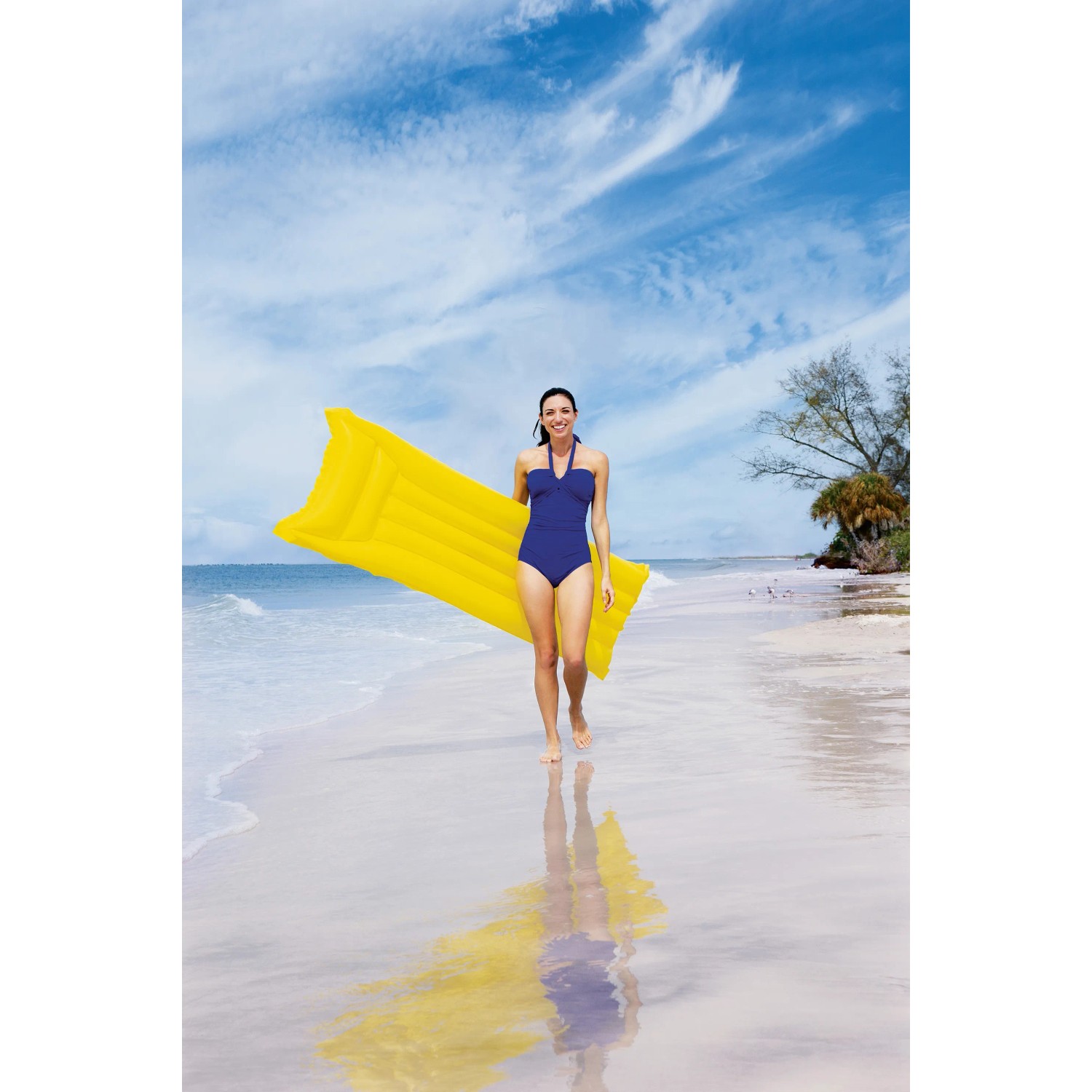 Donna con materassino gonfiabile giallo sulla spiaggia. Ideale per le vacanze estive.