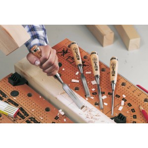 Set scalpelli LUX, 4 pezzi, con manico in faggio all'opera su un banco da lavoro.