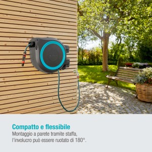 Avvolgitubo a parete con tubo da giardino su parete in legno in giardino.