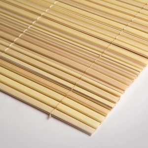 Dettaglio di una stuoia di bambù arrotolata di colore chiaro come frangivista.