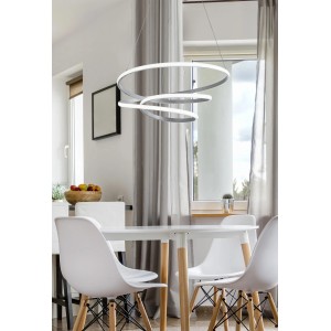 Moderna lampada a sospensione LED t.b.t. con tre anelli sopra il tavolo da pranzo.