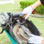 Worx mini smerigliatrice angolare a batteria 20 V WX801.9 in uso per affilare una lama di tosaerba.