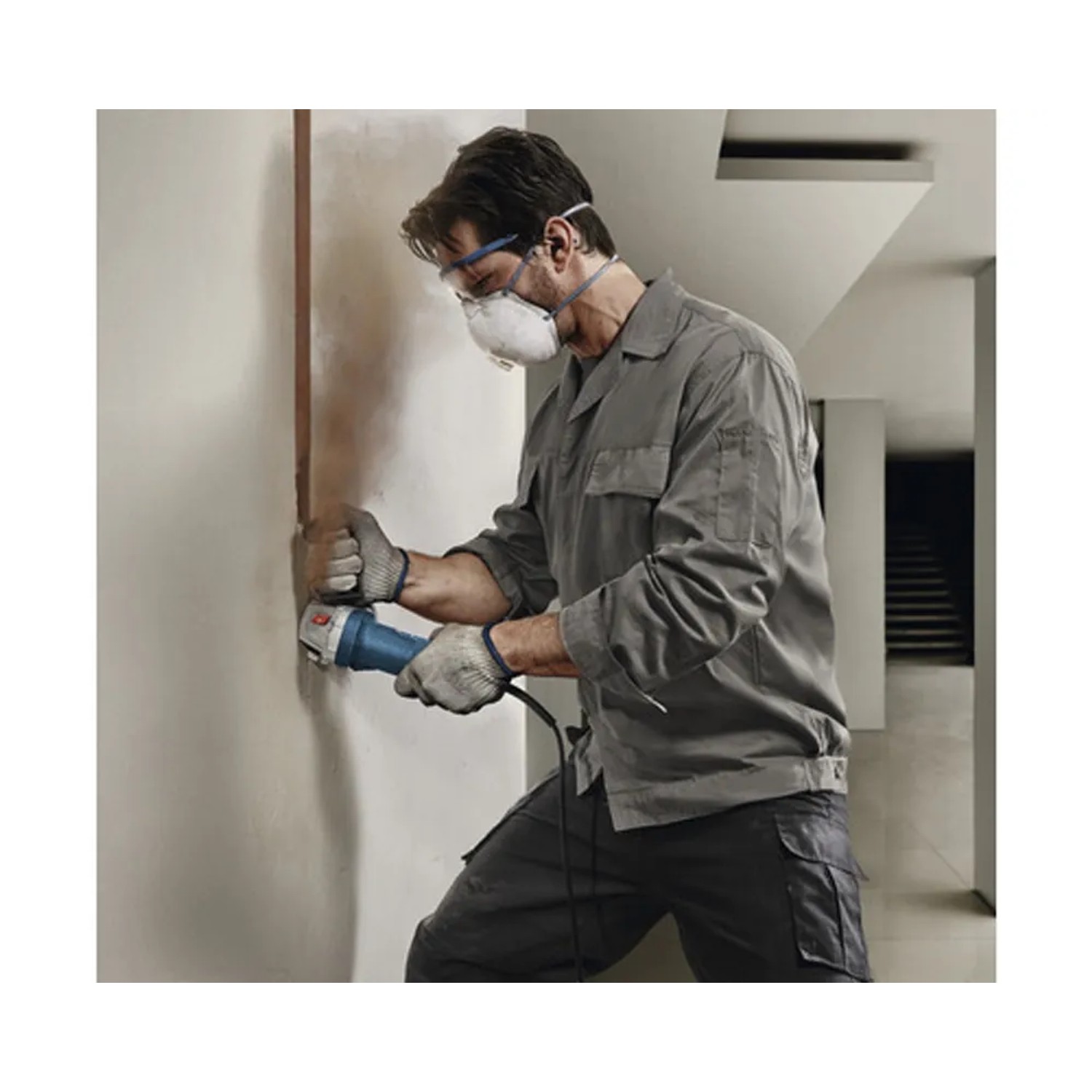 Uomo che leviga la parete con la smerigliatrice angolare Bosch Professional GWS 750-115. Incl. disco abrasivo.