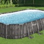 Piscina ovale t.b.t. con effetto legno e telaio in acciaio in giardino.