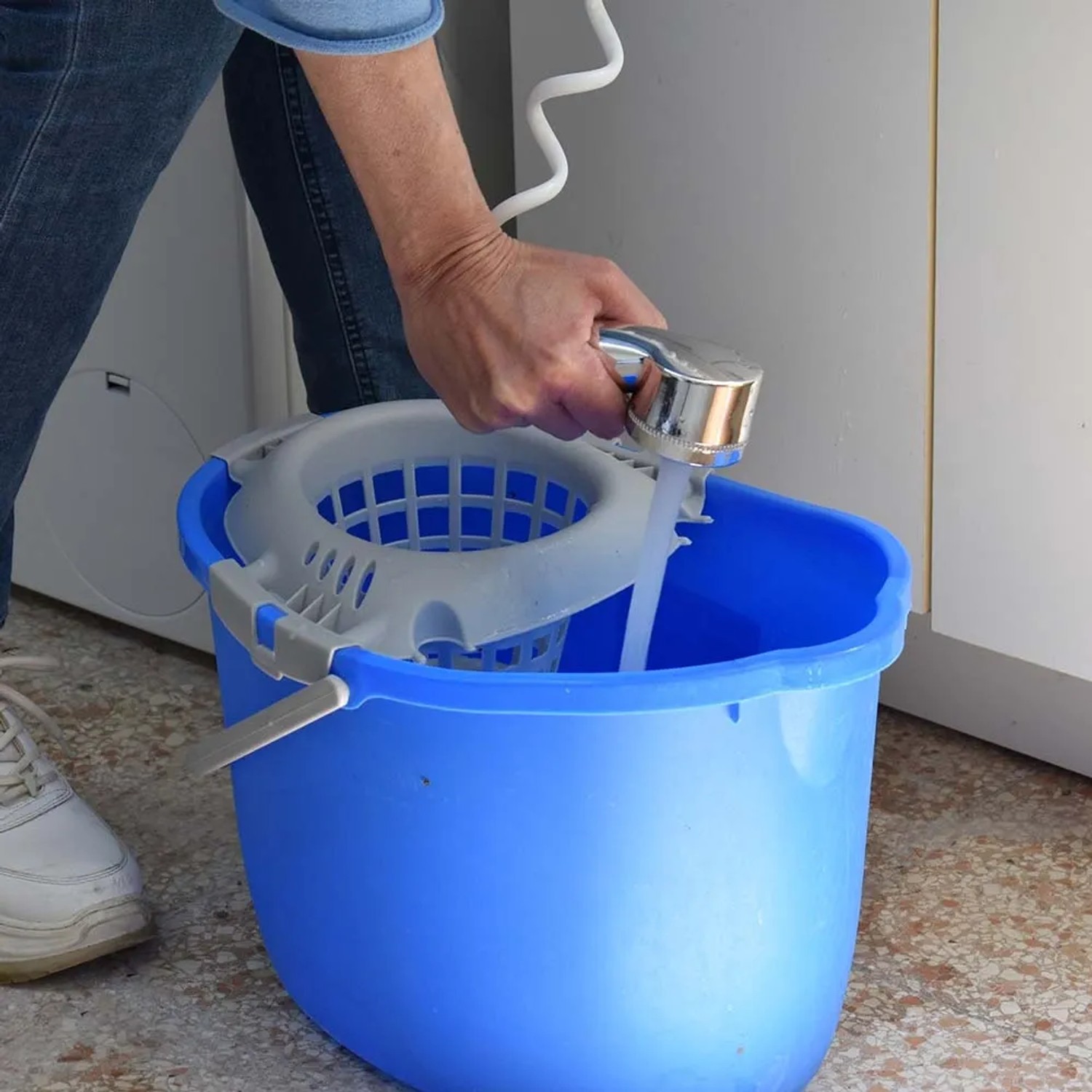 Secchio blu per la pulizia con strizzatore riempito con una doccetta.