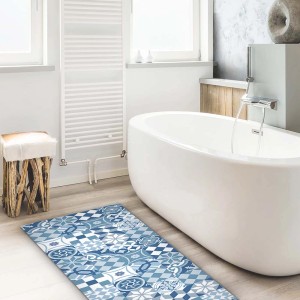 Tappeto/zerbino a motivi blu e bianco in bagno accanto a una vasca.