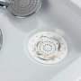 Filtro di scarico Wenko bianco in silicone nel lavandino, cattura i capelli.