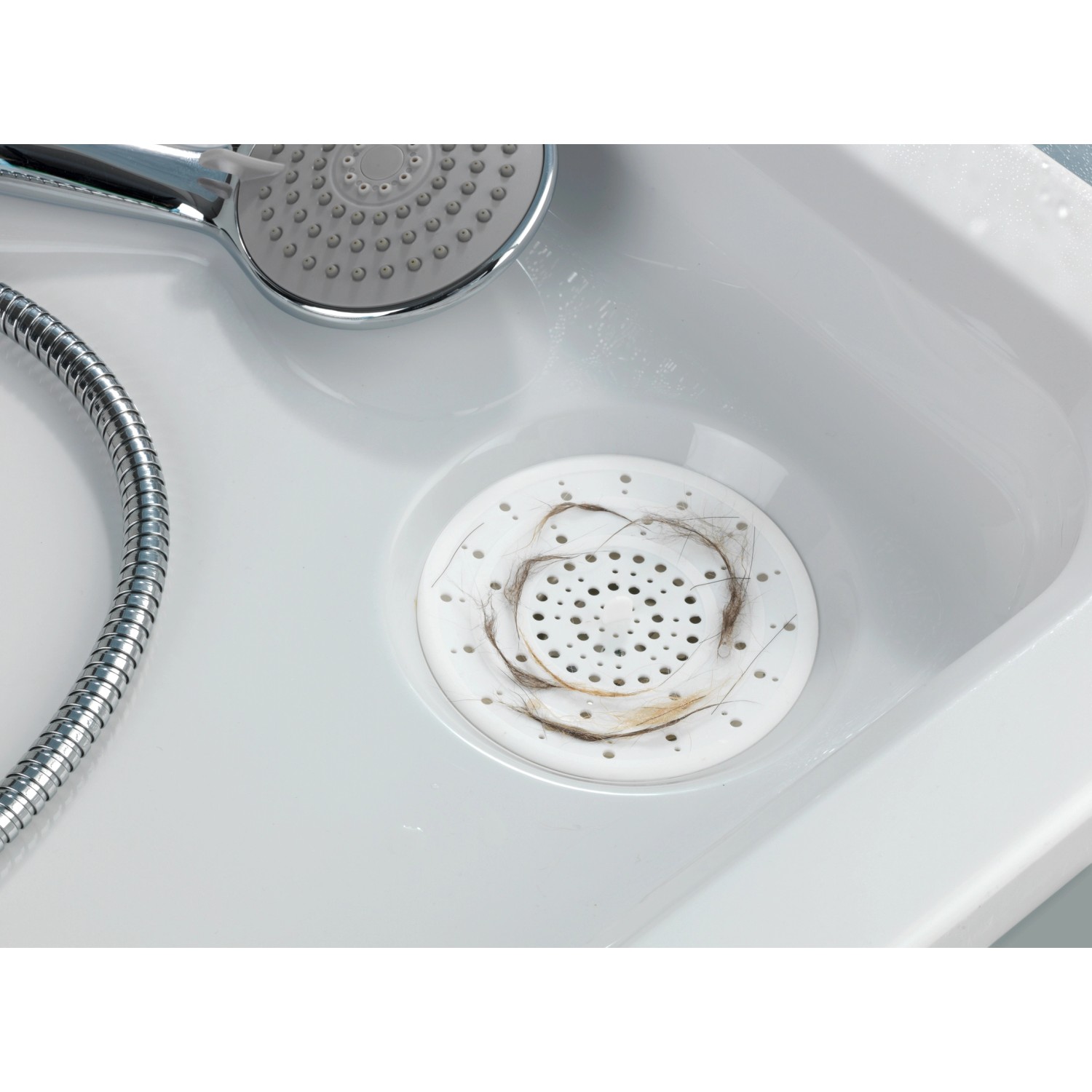 Filtro di scarico Wenko bianco in silicone nel lavandino, cattura i capelli.