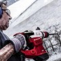Martello demolitore rosso in azione durante la scalpellatura del cemento. Ideale per lavori di demolizione.