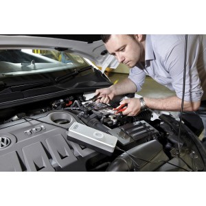 Uomo che collega il caricabatterie t.b.t. alla batteria dell'auto.