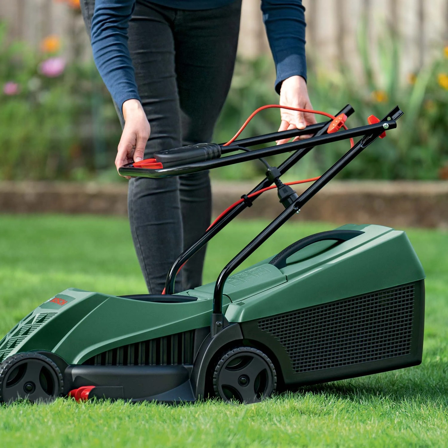 Tagliaerba elettrico Bosch Easy Rotak 32-215 verde con operatore su prato.