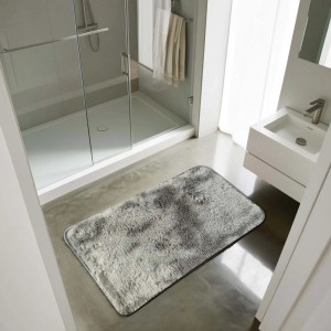 Tappeto a pelo lungo rettangolare grigio in bagno davanti a doccia e lavandino.
