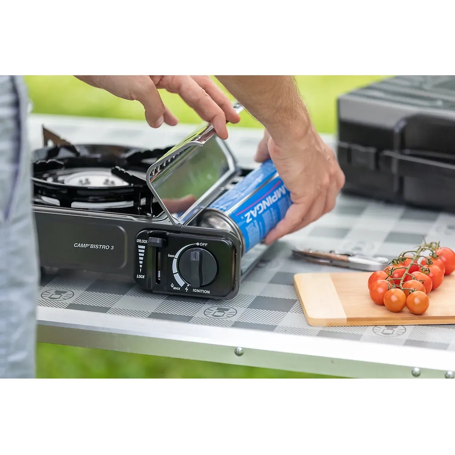 Fornello da campeggio Campingaz Camp'Bistro 3 con cartuccia di gas in fase di inserimento. Ideale per il campeggio.
