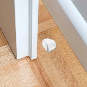 Fermaporta (Fermaporte) bianco a forma di cuneo sul pavimento davanti a una porta.