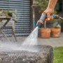 Gardena Comfort Cleaning Sprayer ecoPulse™ in azione durante la pulizia di una superficie in pietra.