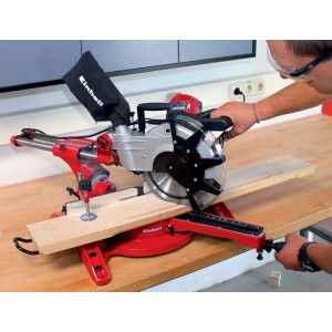 Troncatrice radiale Einhell TC-SM 2534 Dual rossa/argento mentre taglia un pezzo di legno.