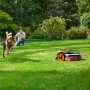 Robot rasaerba Worx Landroid Vision M800 in azione con cane e uomo in giardino.