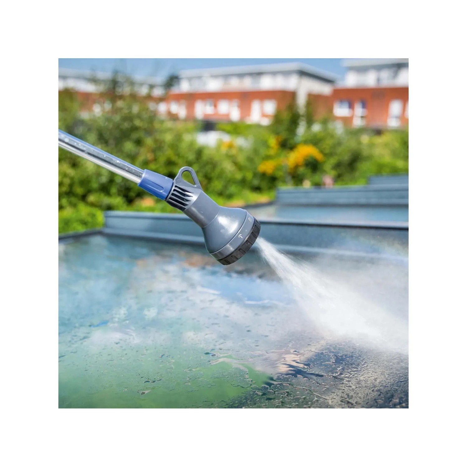 Pistola a spruzzo grigia t.b.t. con getto d'acqua per irrigare il giardino.