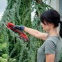 Donna taglia rami con cesoie a batteria Einhell Power X-Change GE-LS 18 Li-Solo in giardino.