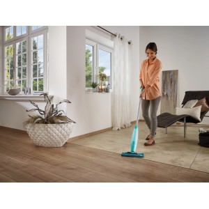 Donna che utilizza il mocio spray Leifheit Pico Spray S per pulire il pavimento del soggiorno.