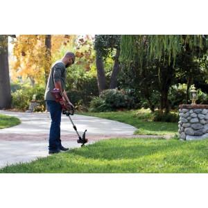 Tagliabordi a batteria t.b.t. in uso: uomo taglia l'erba in giardino.