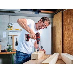 Uomo che fora un pezzo di legno con avvitatore a batteria t.b.t.