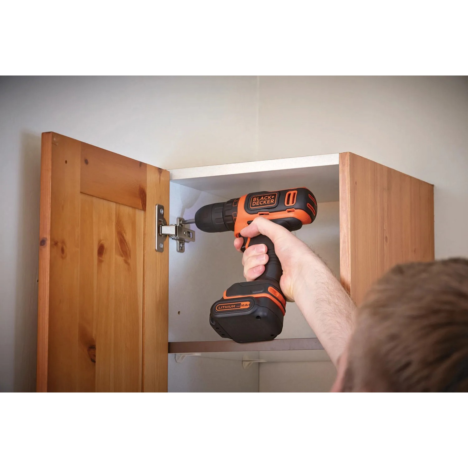 Avvitatore a batteria Black+Decker che avvita un armadio in legno.