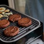 Campingaz Attitude 2go CV grill a gas con hamburger e verdure sulla griglia.