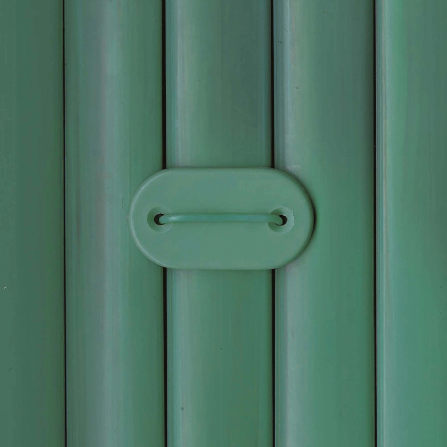 Dettaglio di una recinzione frangivista verde con maniglia.